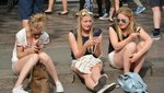 Drei junge Frauen schauen auf ihr Handy