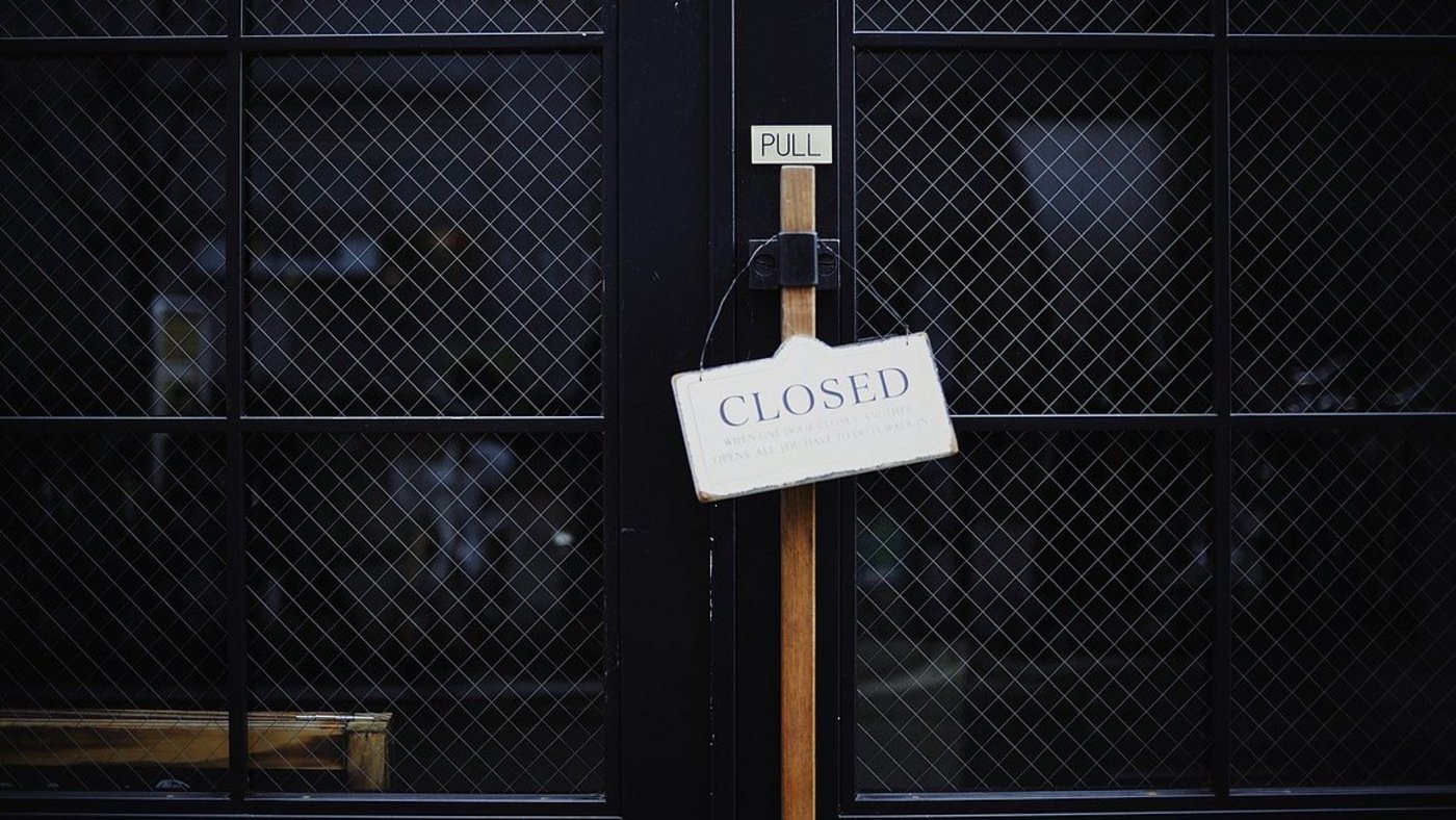 a barred, locked door with a sign "closed"