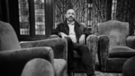 Portrait of Yves Moreau sitting on a sofa