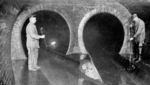 Arbeiter prüfen Regenüberlaufbauwerk (um 1930)